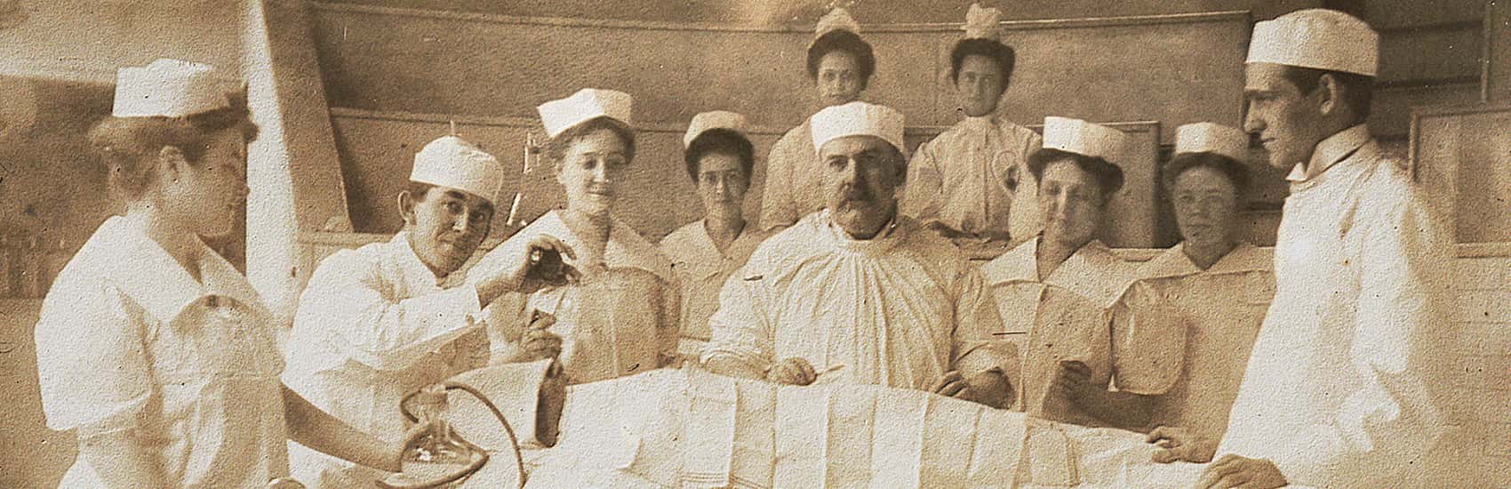 Historical photo of doctors and nurses standing around patient in surgical theater