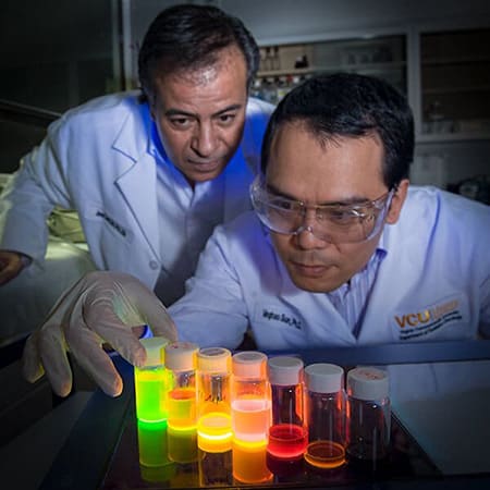 Two researchers examining liquids of different colors