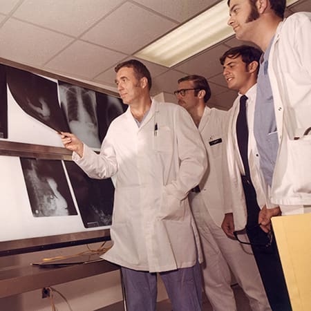 Historical photo of organ transplant doctors looking at X-rays