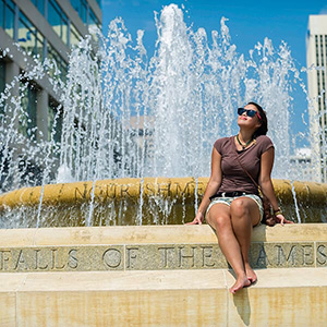 Woman sitting in front of fountain