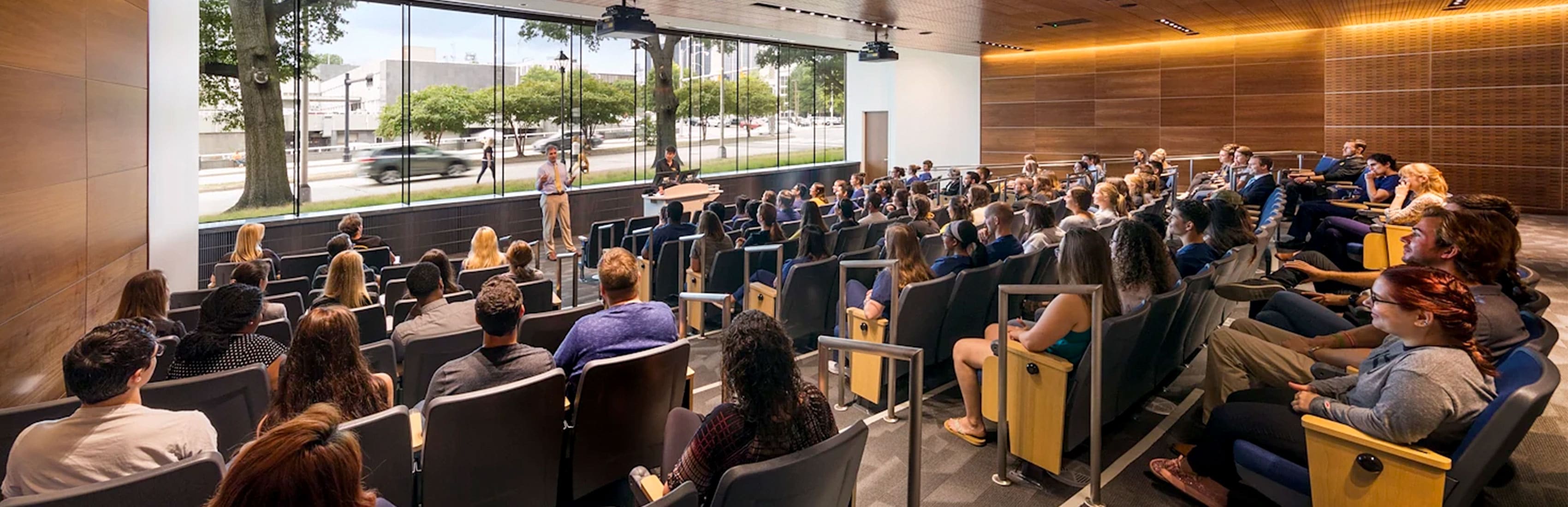 Students sit in a large lecture hall.