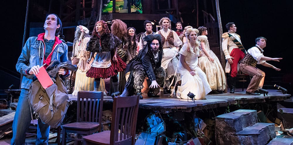 Students in costume performing on stage during Into the Woods production