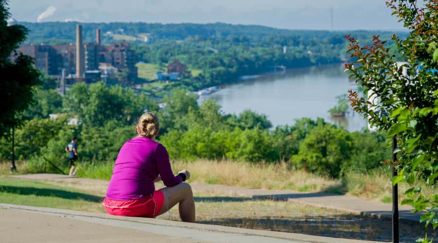 Woman sitting in park looking at view of James River