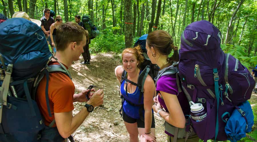 Students in woods wearing hiking backpacks