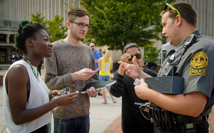 VCU Police officer talking to students on the Compass