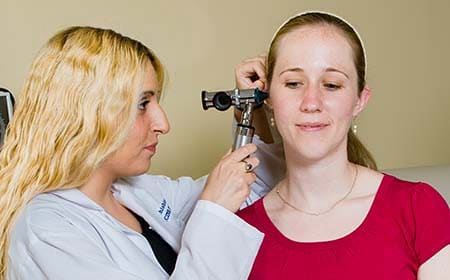 Doctor examining woman’s ear
