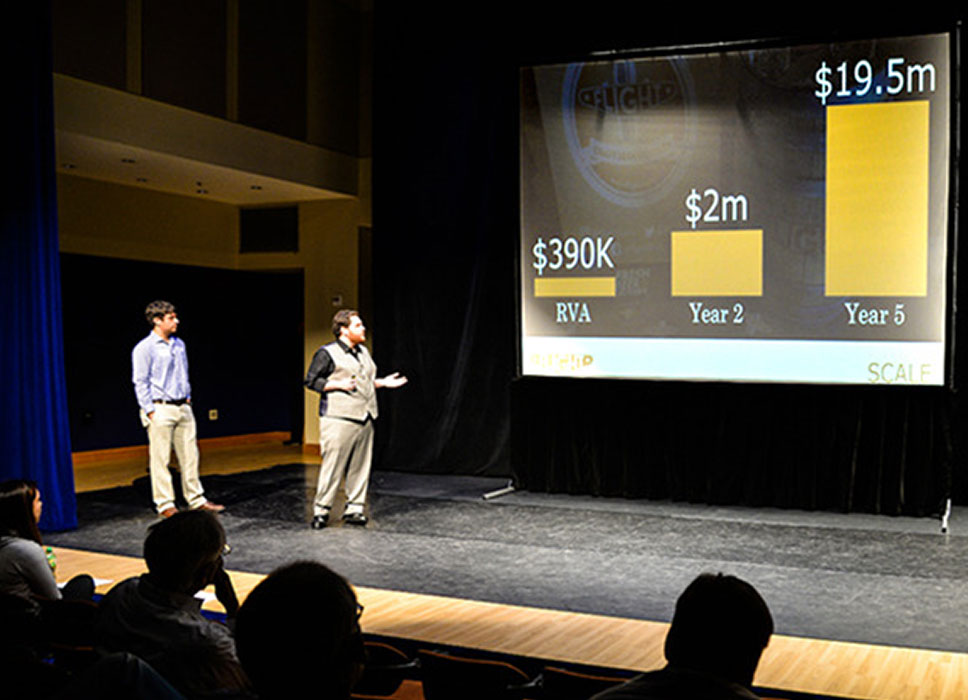 Two students making a presentation on a stage